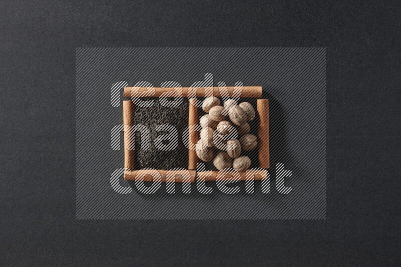 2 squares of cinnamon sticks full of tea and nutmeg on black flooring