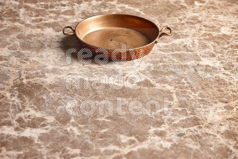 Small Copper Pan on Beige Marble Flooring, 45 degrees