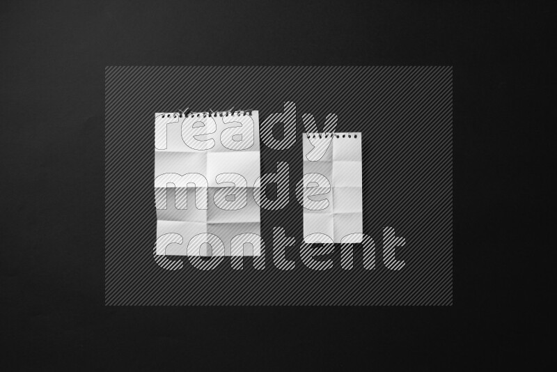 Folded notebook sheet on black background