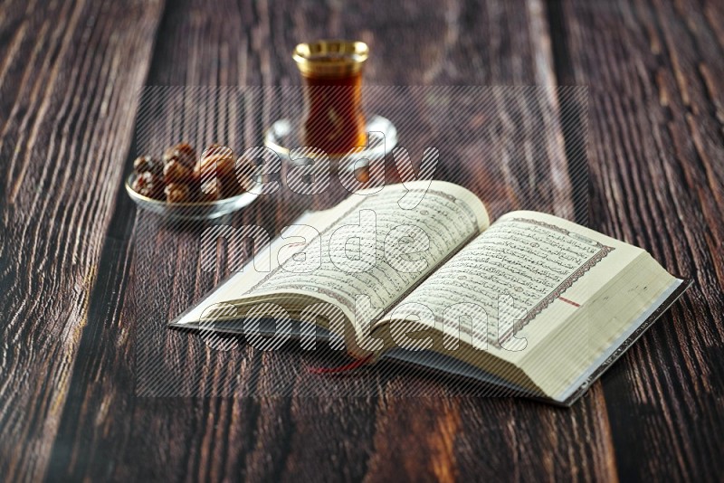 Quran with dates, prayer beads and different drinks all placed on wooden background