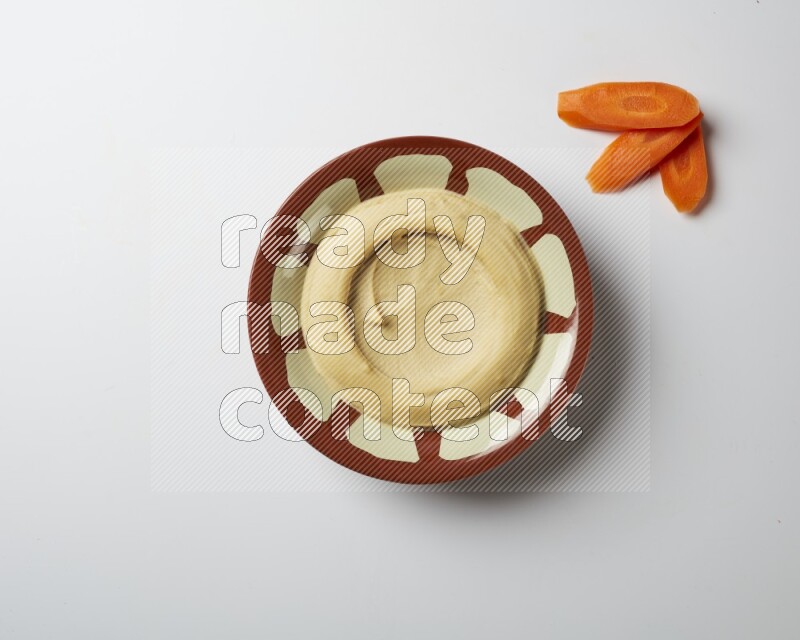 Plain hummus in a traditional plate on a white background
