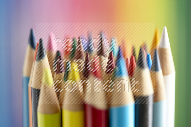 The image captures a close-up of sharpened colored pencils on multicolored background