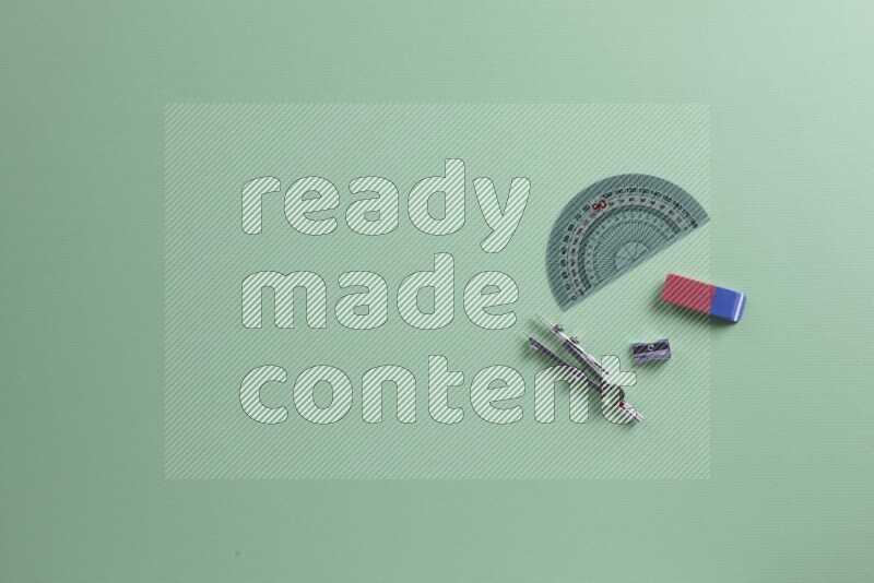 مستلزمات مدرسية مختلفة على خلفية خضراء