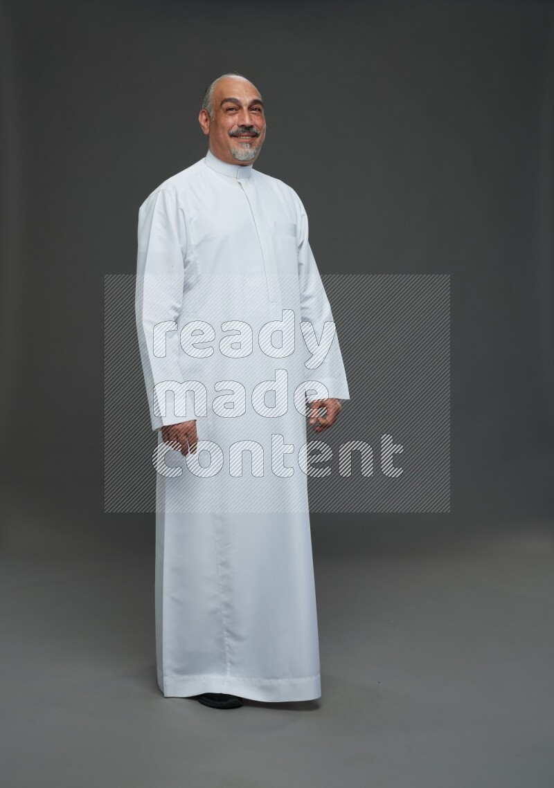 Saudi man without shomag Standing Interacting with the camera on gray background