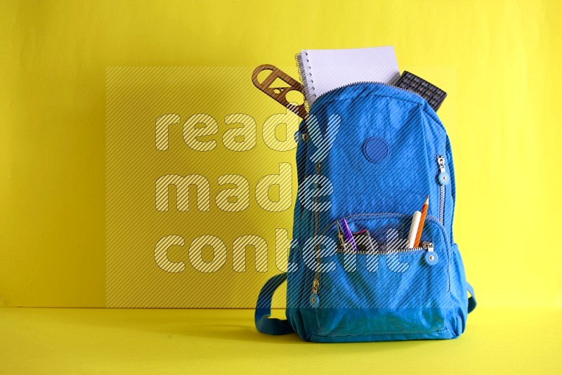 A school bag on yellow background in different angles (back to school)