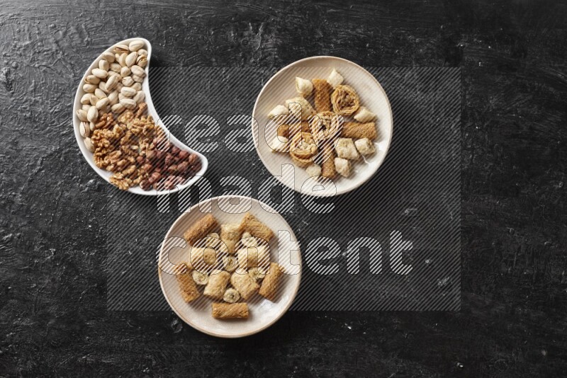 Oriental sweets in pottery plates with nuts in a dark setup