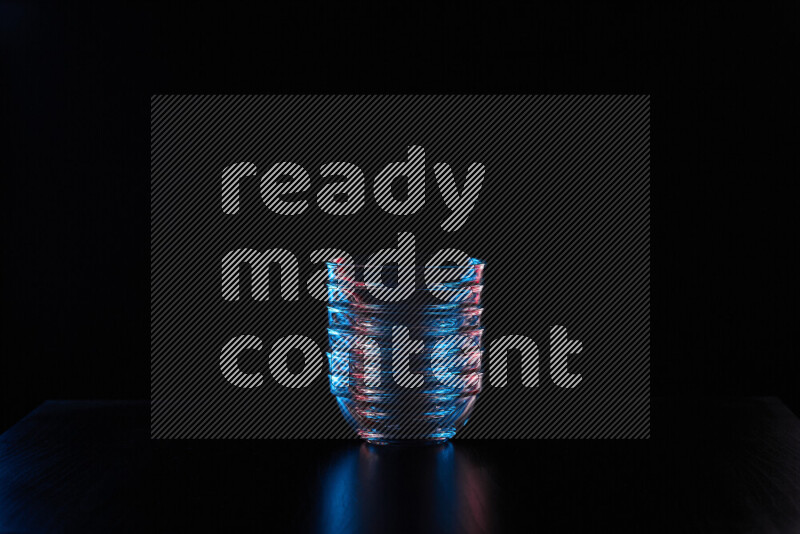 Glassware with rim light in red and blue against black background