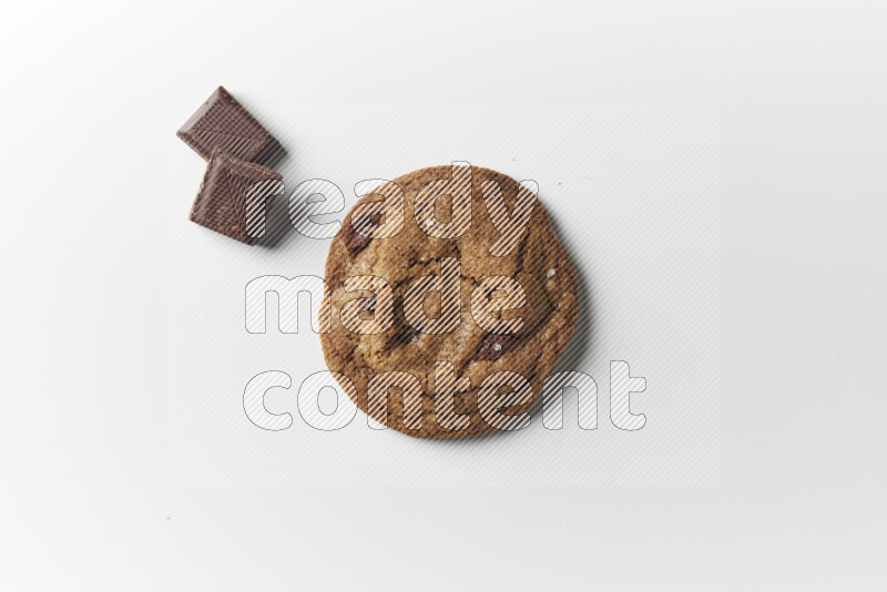 A single chocolate chips cookie with chocolate beside it on a white background