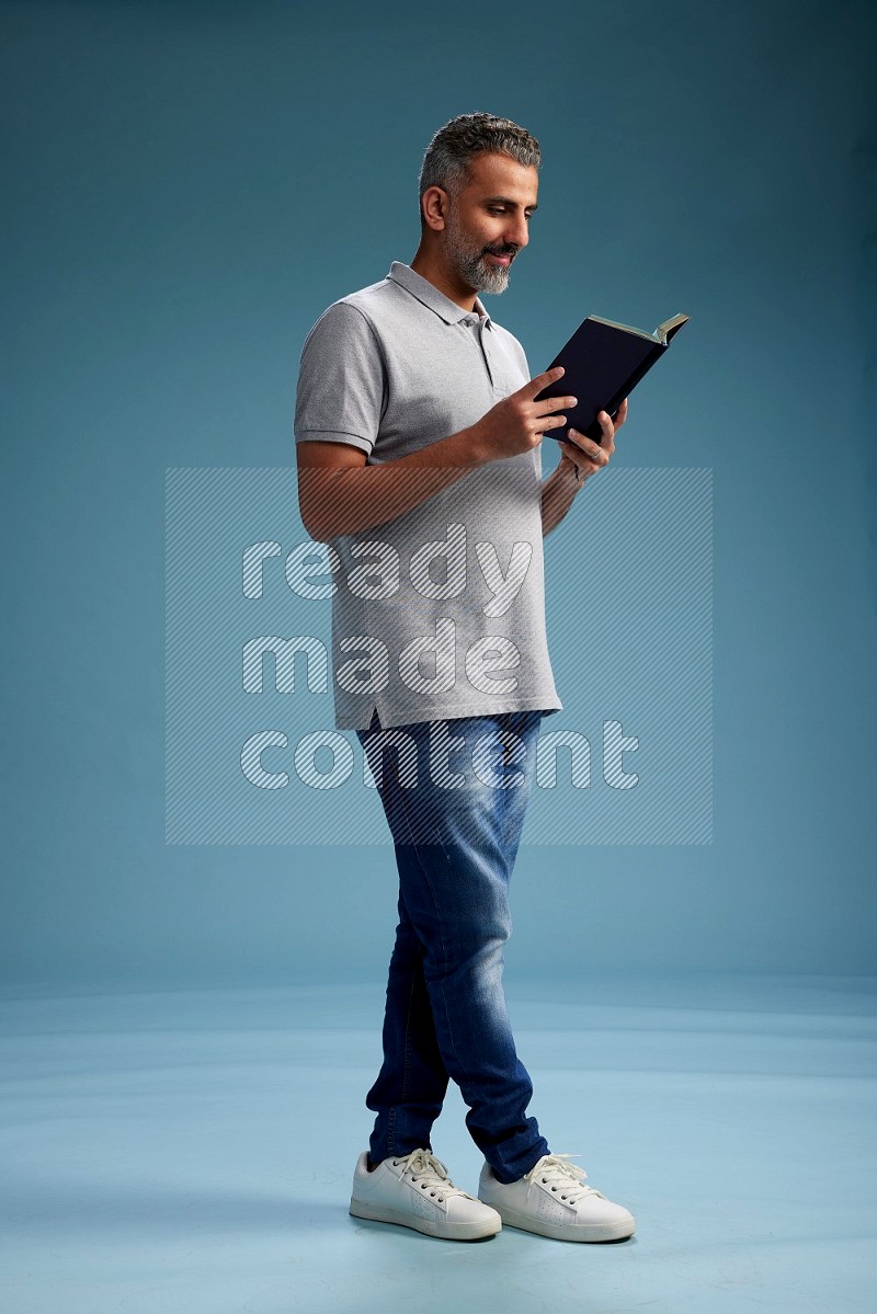 Man Standing reading book on blue background