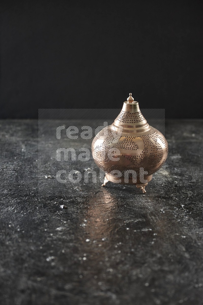 A lantern placed on a textured black background