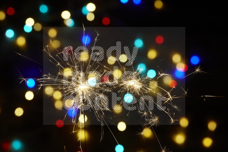 Sparkler candles with multicolored light bokeh background