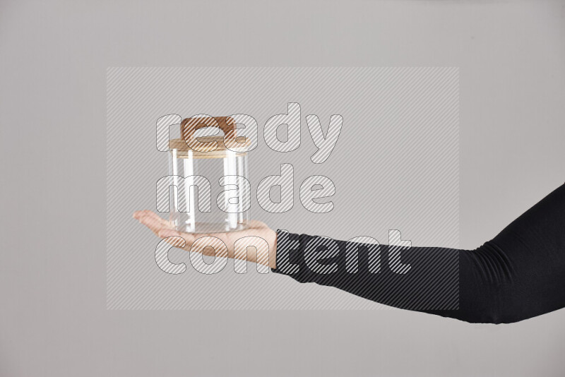 A woman in black abaya holding different glassware in different positions
