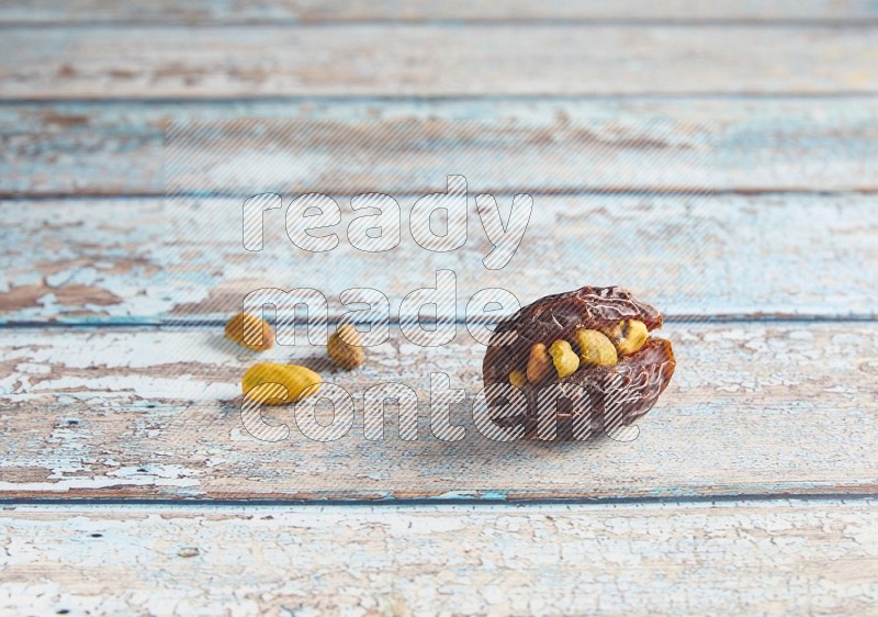 pistachio stuffed madjoul date on a light blue wooden background