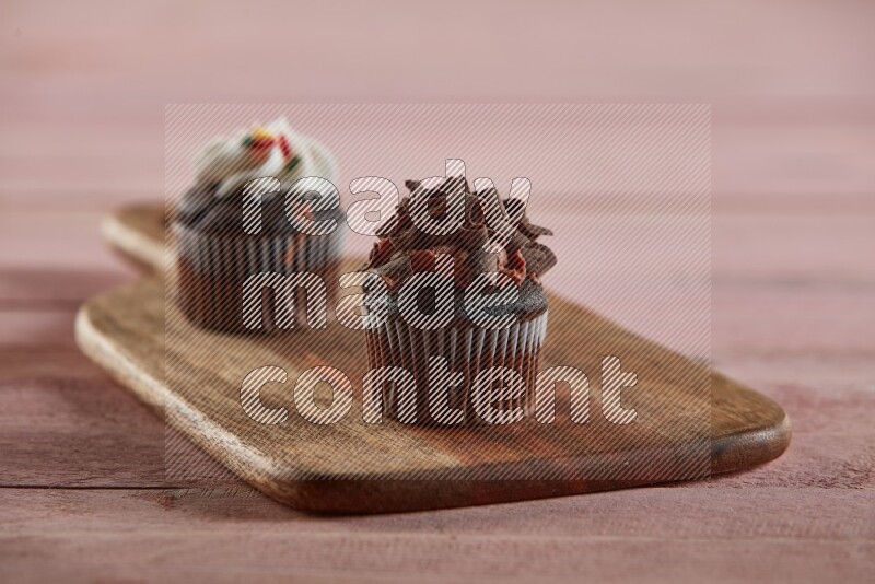 Chocolate mini cupcake topped with chocolate curls on a wooden board