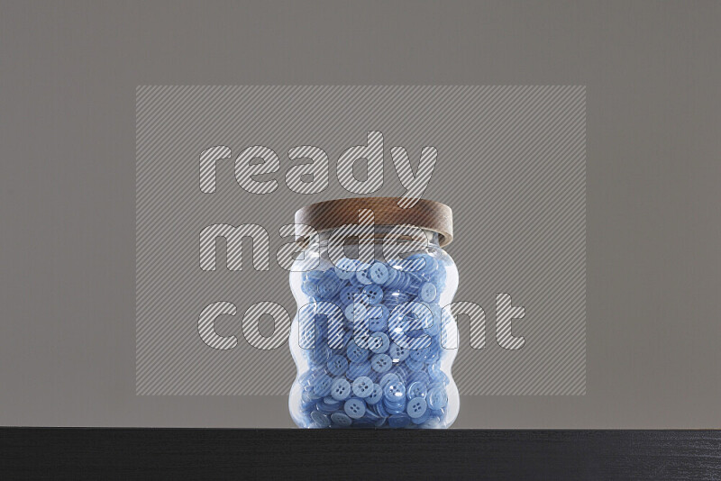 Buttons in a glass jar on black background
