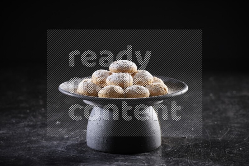 Kahk on a serving plate on a black background