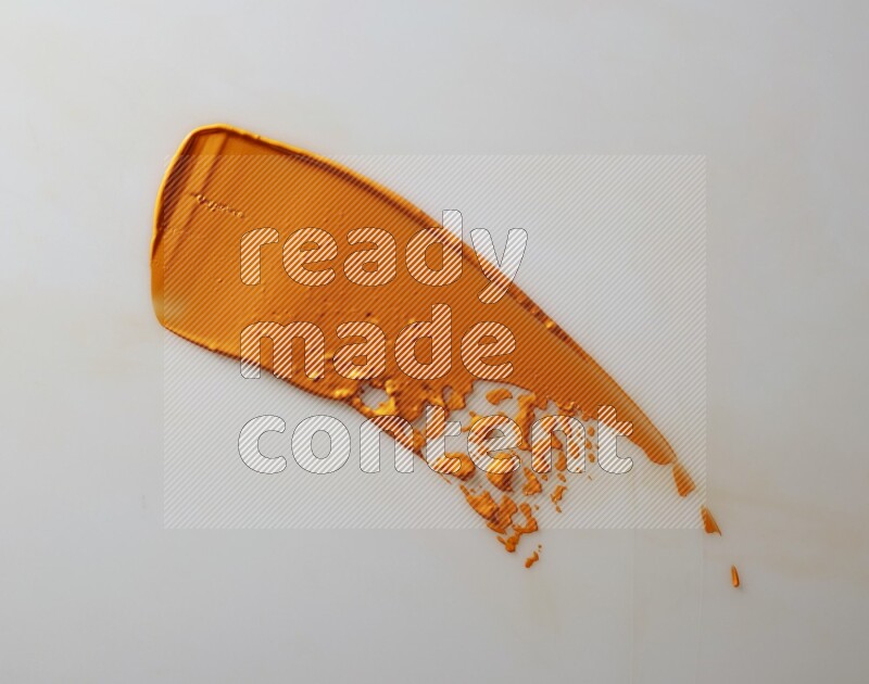 An orange single curved painting knife stroke on white background