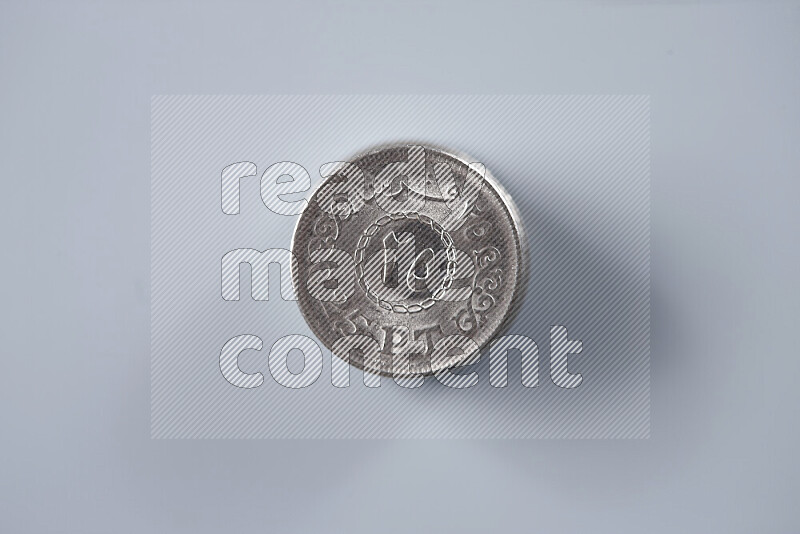 كومة من عملات النقود المصرية بقيمة 25 قرش على خلفية رمادية