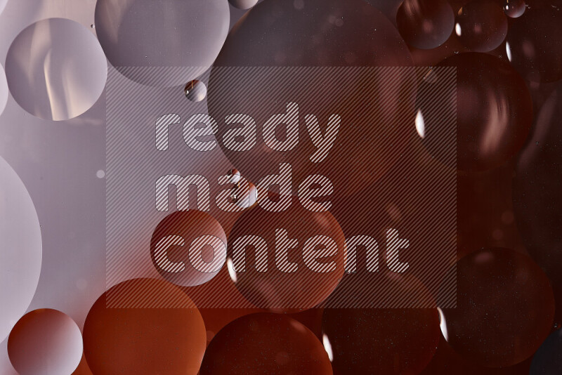 Close-ups of abstract oil bubbles on water surface in shades of black and orange