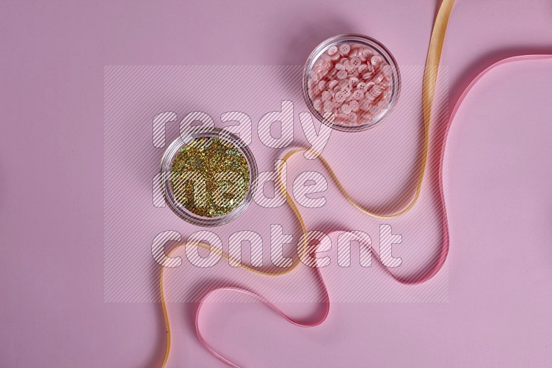 Yellow sewing supplies on pink background