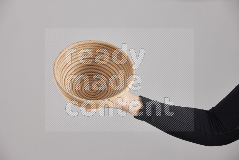 امرأة ترتدي عباءة سوداء تحمل أدوات خشبية مختلفة في أوضاع متعددة