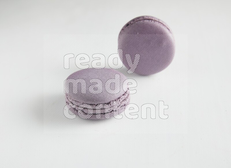 45º Shot of two Purple Blueberry macarons on white background