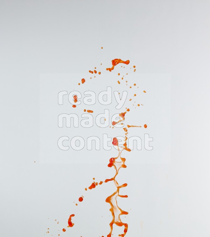 Orange liquid splash and drops on white background