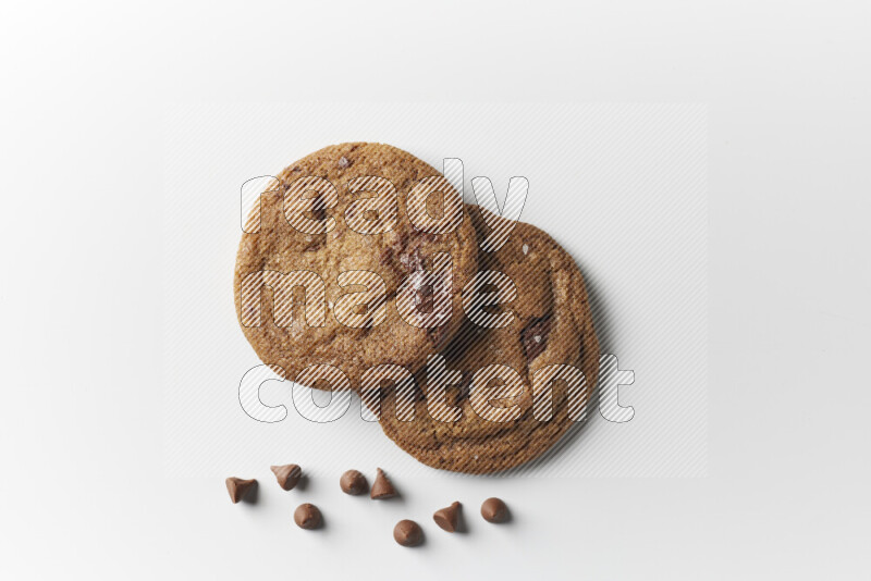 Chocolate chips cookies with chocolate beside it on a white background