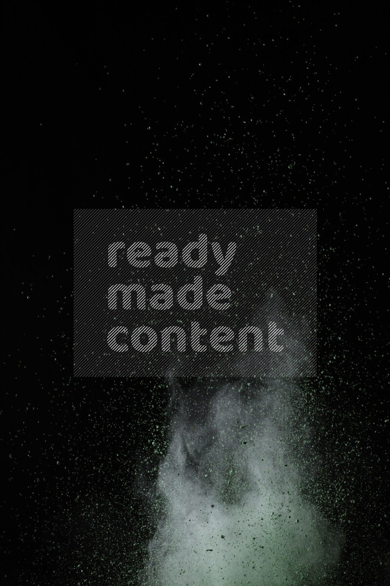 A side view of green powder explosion on black background