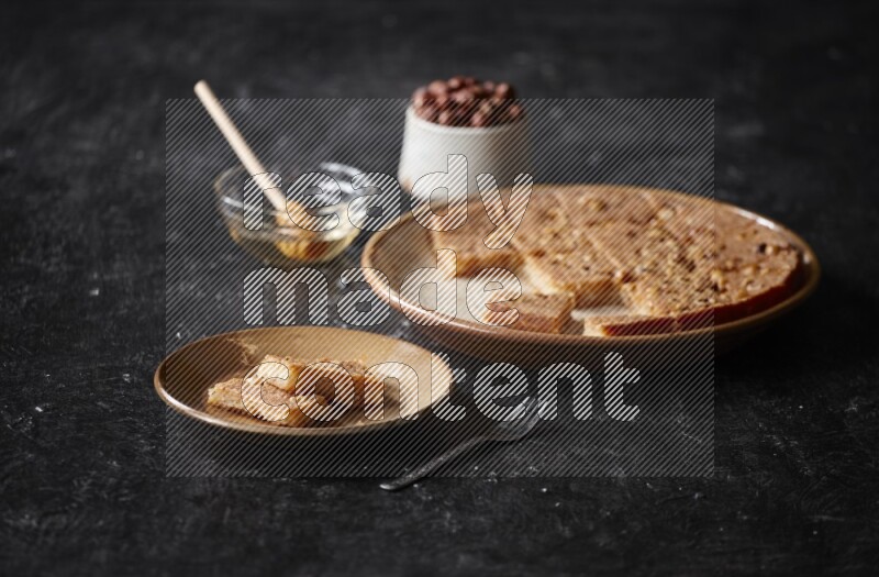 بسبوسة بالمكسرات والعسل علي خلفية سوداء خشبية