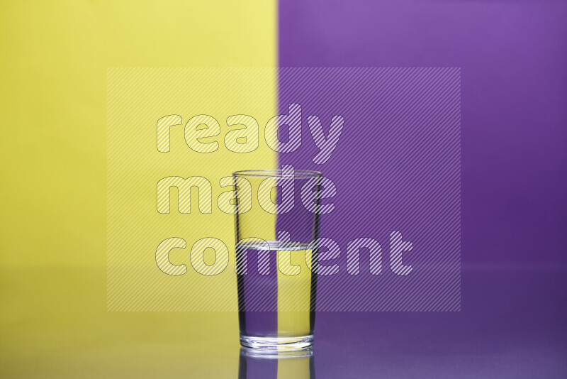 تظهر الصورة أواني زجاجية ممتلئة بالماء موضوعة على خلفية من اللونين الأصفر والأرجواني