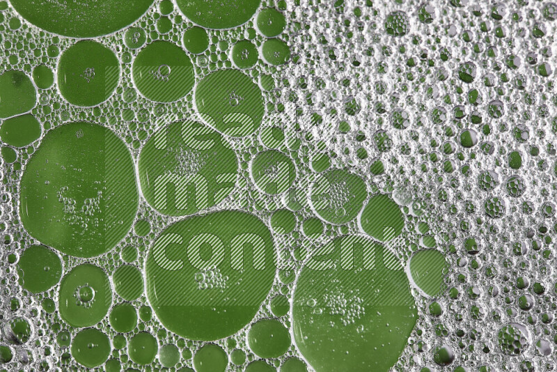 Close-ups of abstract soap bubbles and water droplets on green background