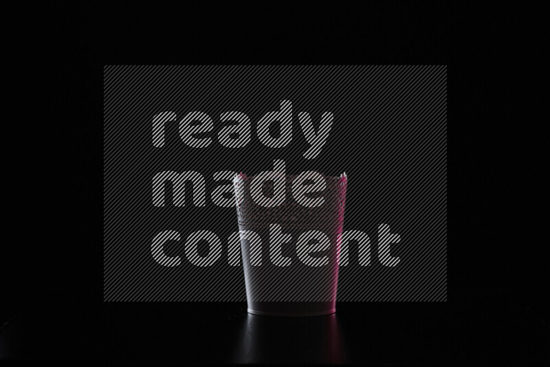 A plant pot with colored rim light against black background