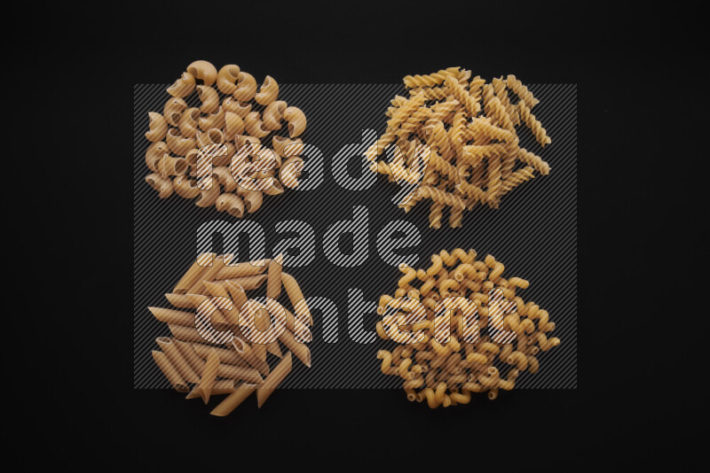 Different pasta types in bunches on black background