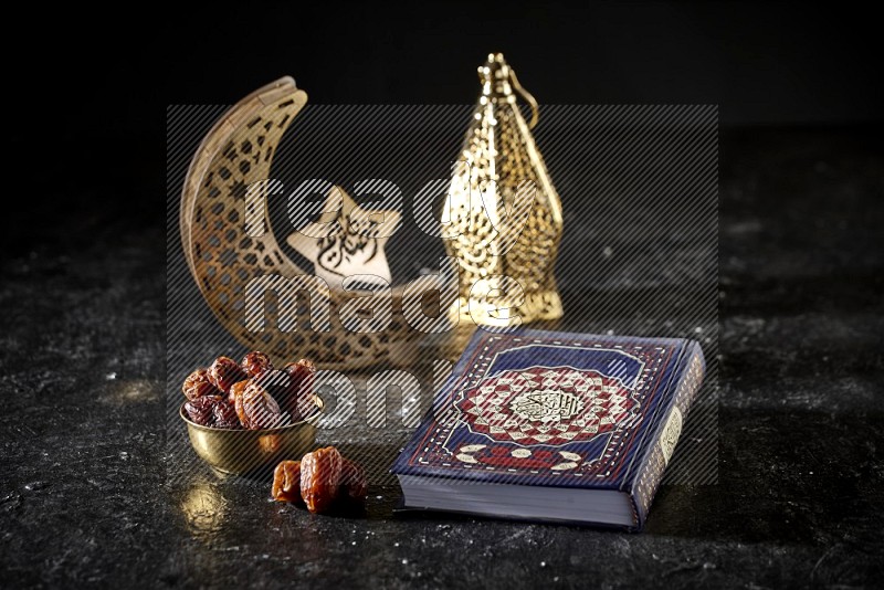 Dates in a metal bowl with quran beside golden lanterns in a dark setup