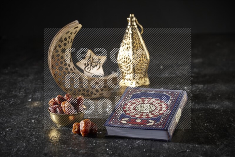 Dates in a metal bowl with quran beside golden lanterns in a dark setup