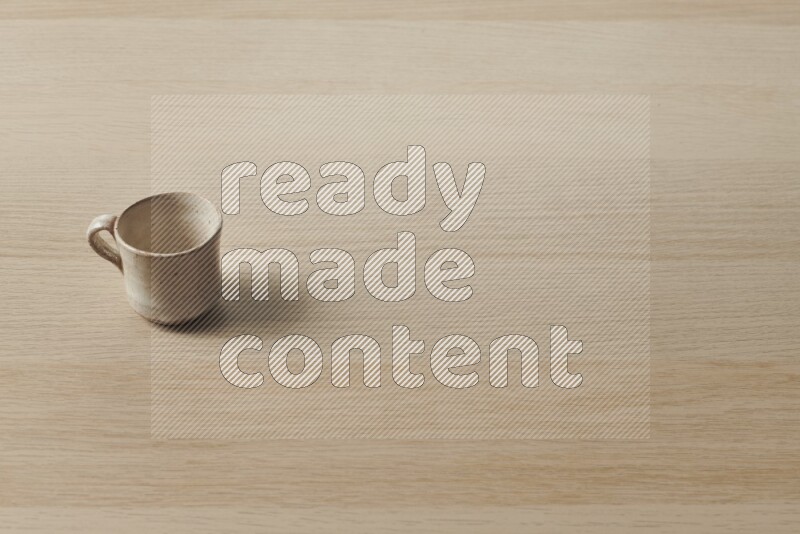 A pottery cup on light wooden background