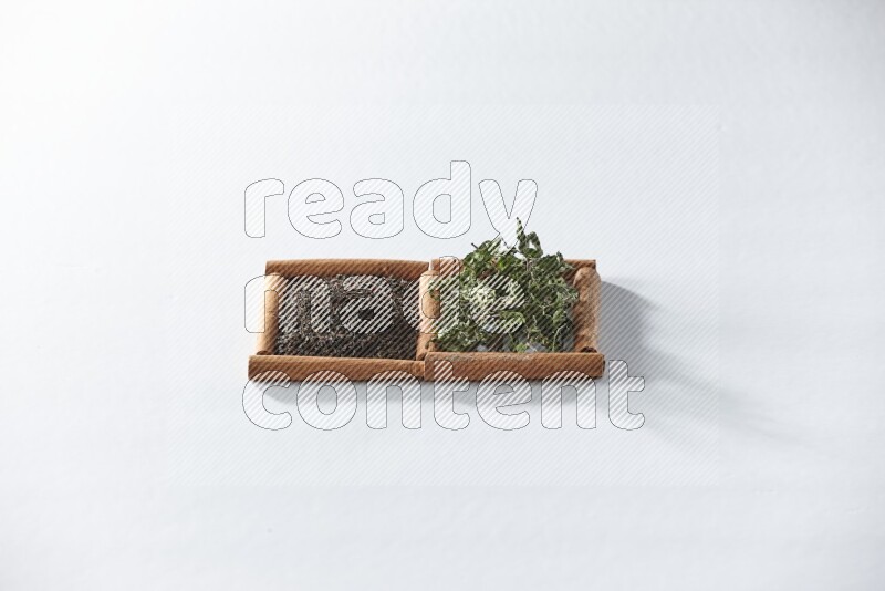 2 squares of cinnamon sticks full of black tea and dried mint leaves on white flooring