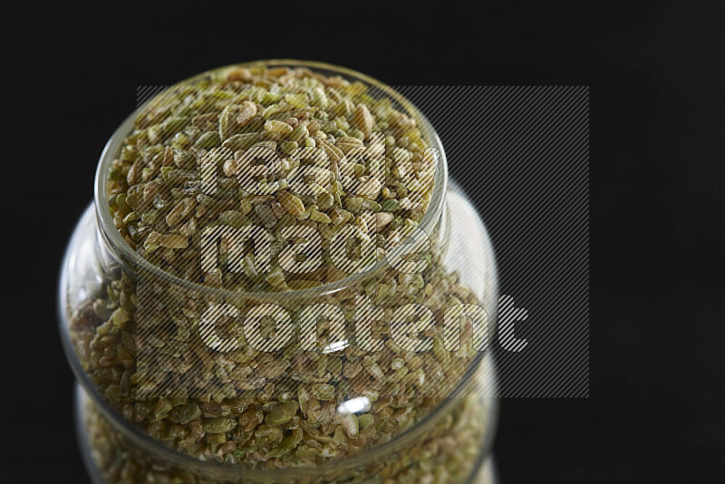 Freekeh in a glass jar on black background