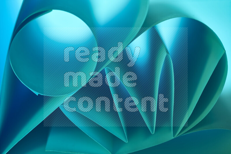 عرض فني لطيات الورق تخلق مزيج من الأشكال الهندسية، مضاءة بإضاءة ناعمة بدرجات اللون الأخضر والأزرق