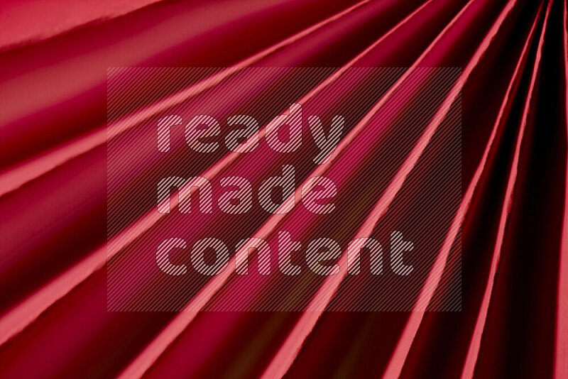 An image presenting an abstract paper pattern of lines in red tones
