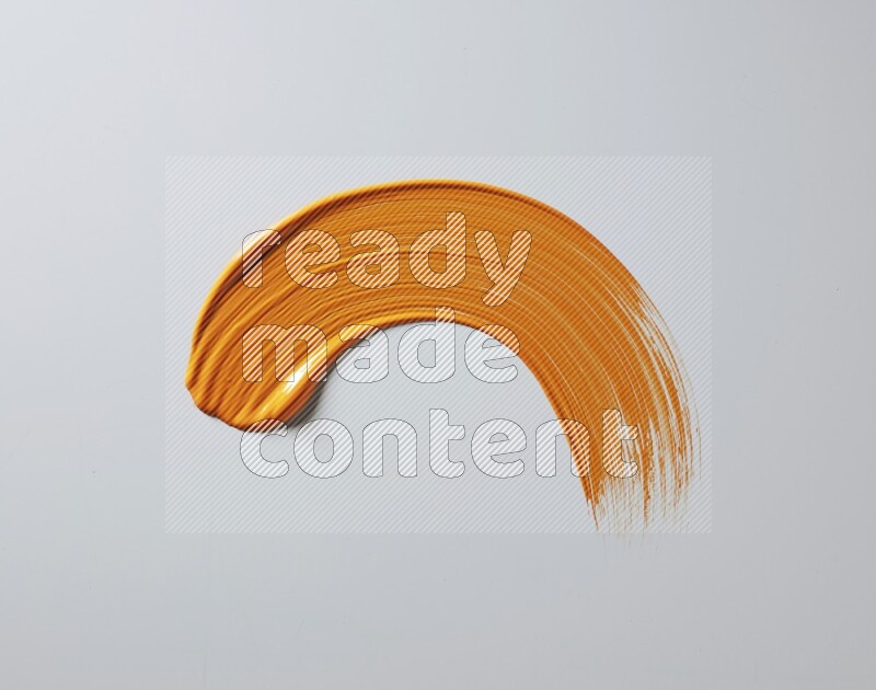 An orange half circular painting brush stroke on white background