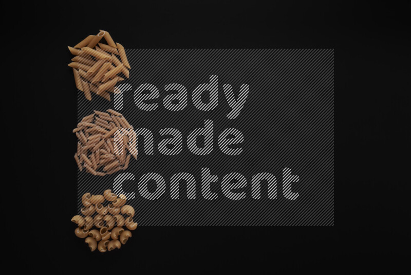 Different pasta types in 3 bunches on black background