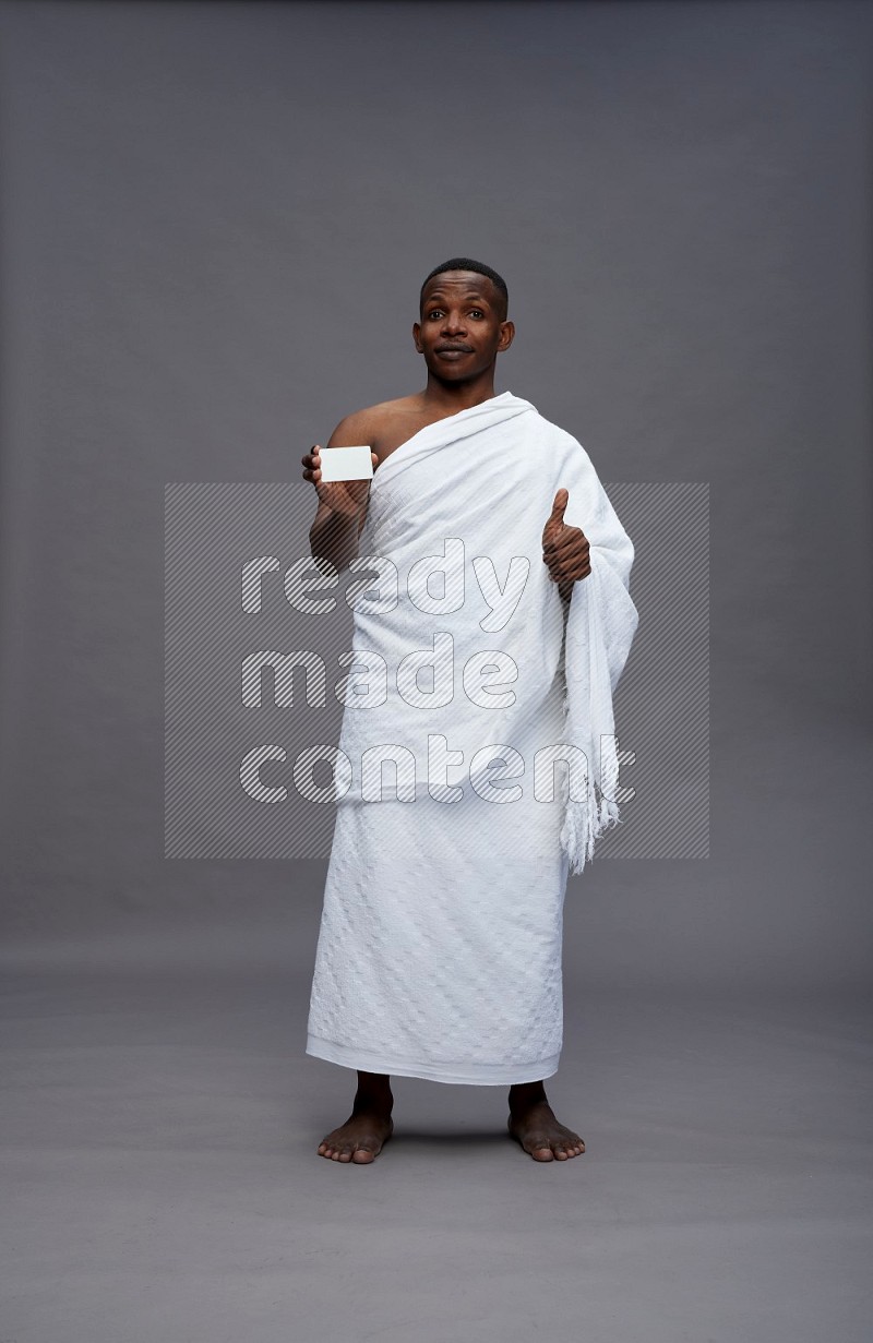 A man wearing Ehram Standing holding ATM card on gray background