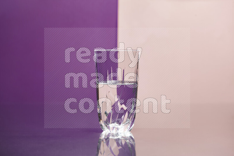 The image features a clear glassware filled with water, set against purple and rose background