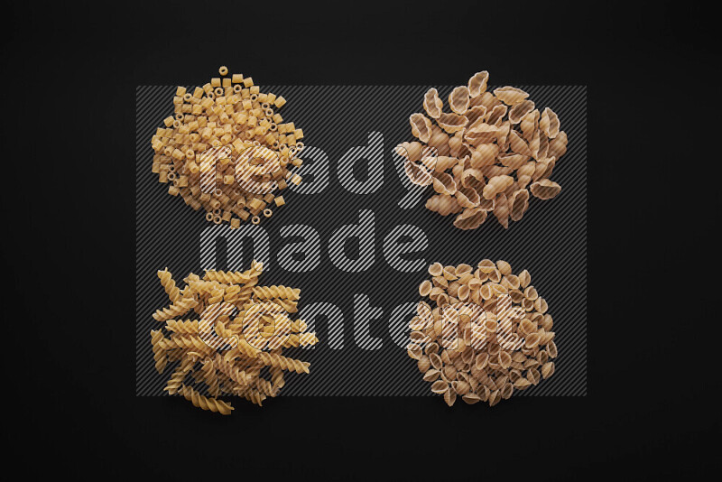 Different pasta types in bunches on black background