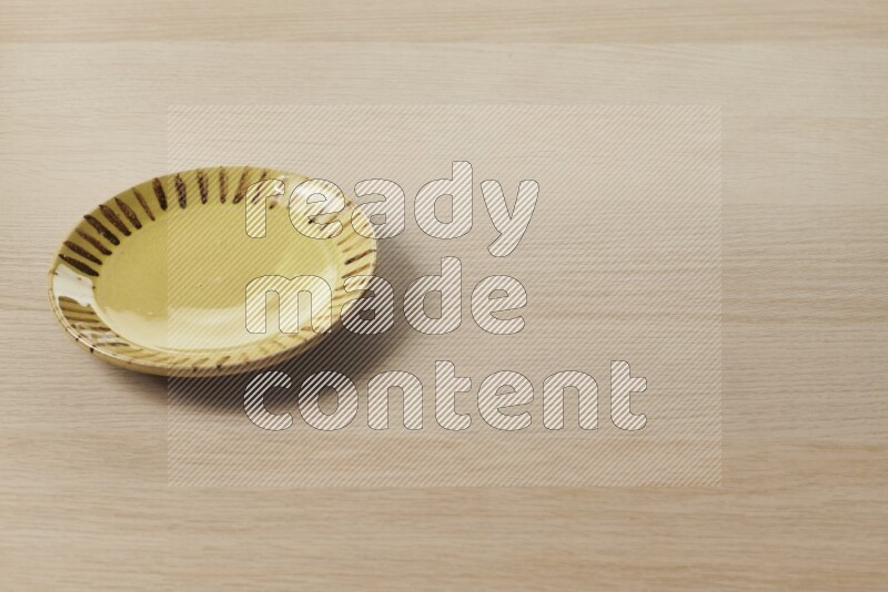 A multicolored pottery plate on light wooden background