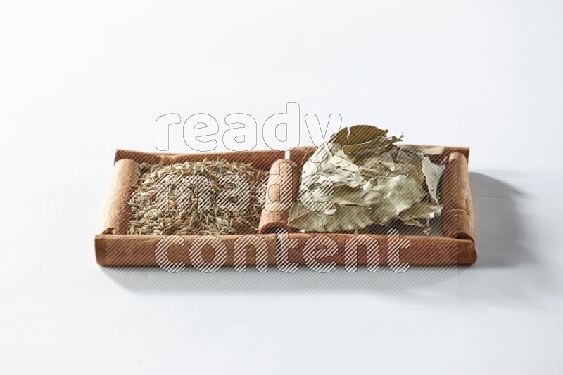 2 squares of cinnamon sticks full of bay laurel leaves and cumin on white flooring
