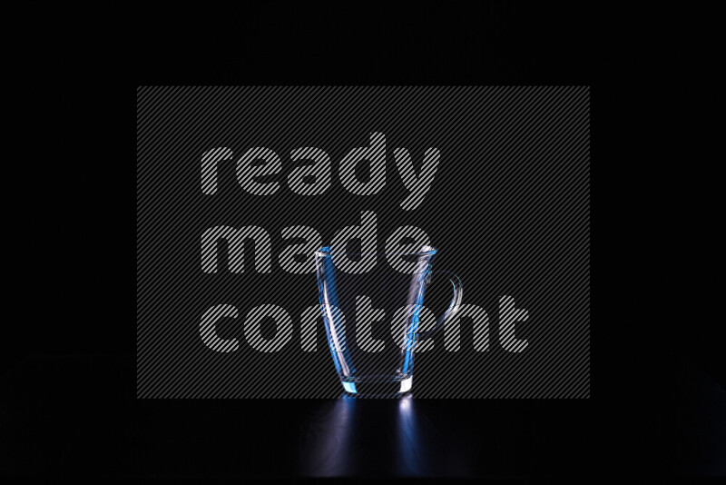 Glassware with rim light in blue and white against black background