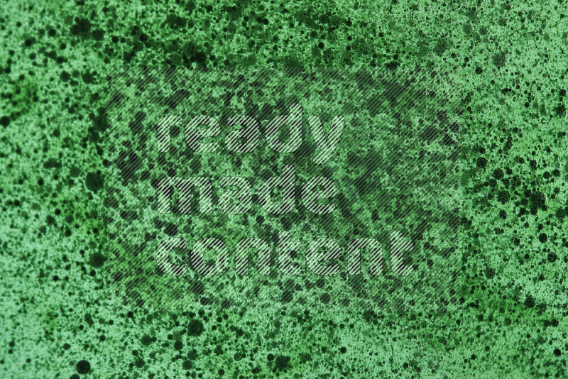 لقطات مقربة لقطرات ألوان مائية خضراء على سطح الزيت على خلفية خضراء